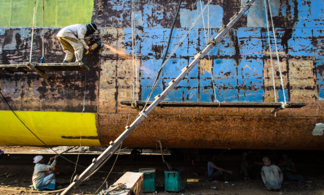 Workers welding parts of ship in bangladesh