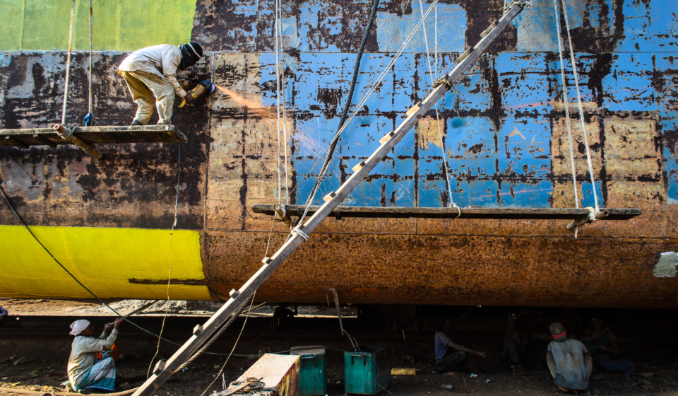 Workers welding parts of ship in bangladesh